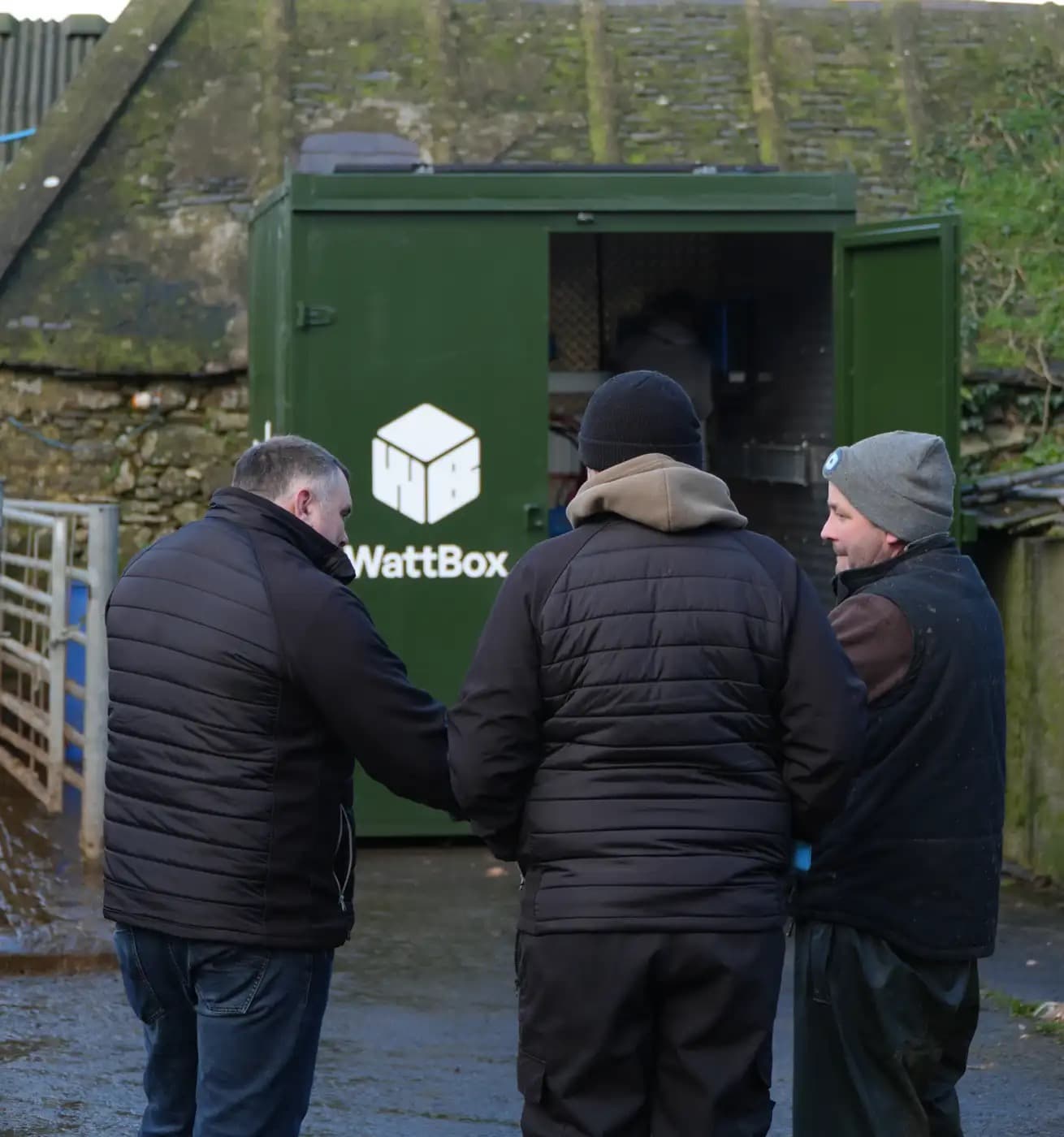 A WattBox engineer talking with a farmer in front of a container